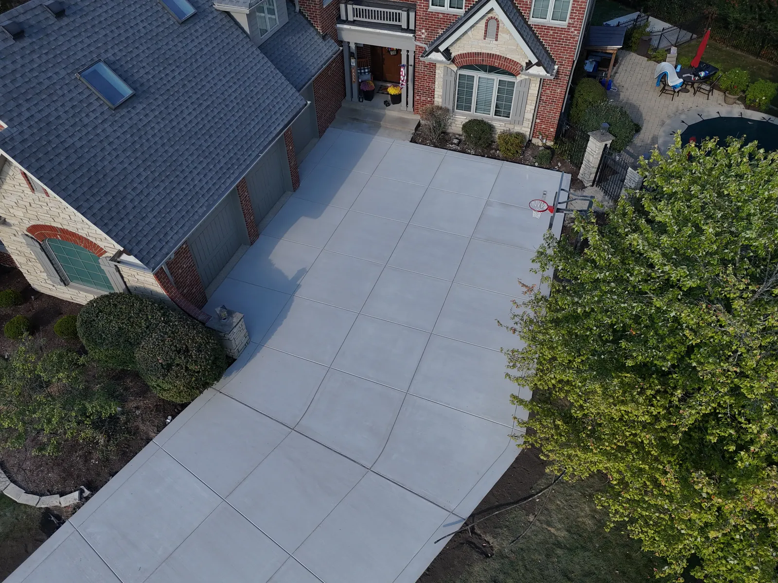 Large concrete driveway at upscale brick and stone home