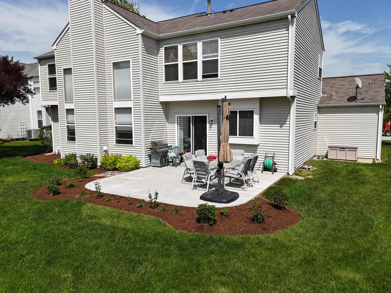 Organic-shaped concrete patio with fresh landscaping — aerial