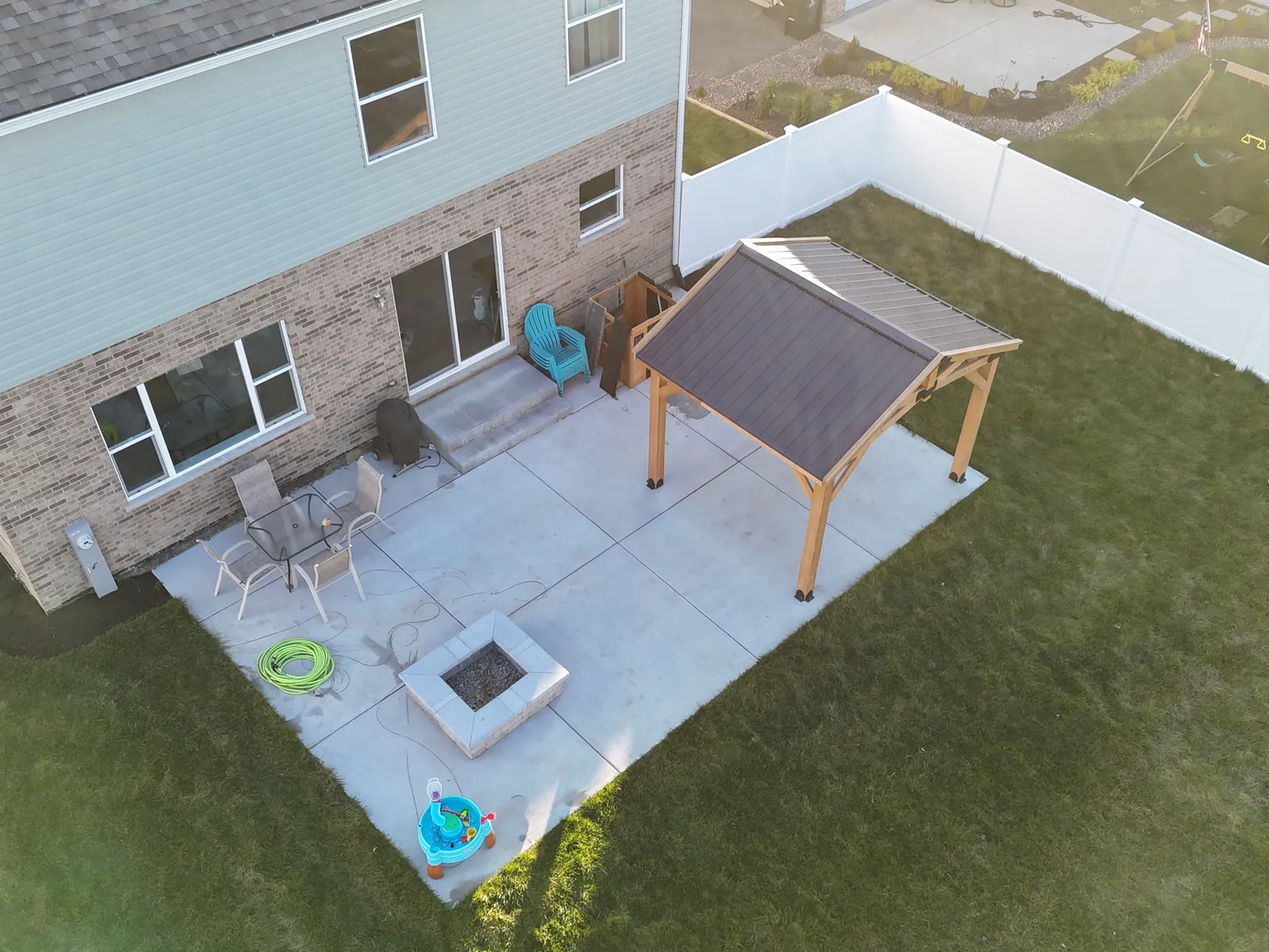 Broom-finish concrete patio with pergola and fire pit