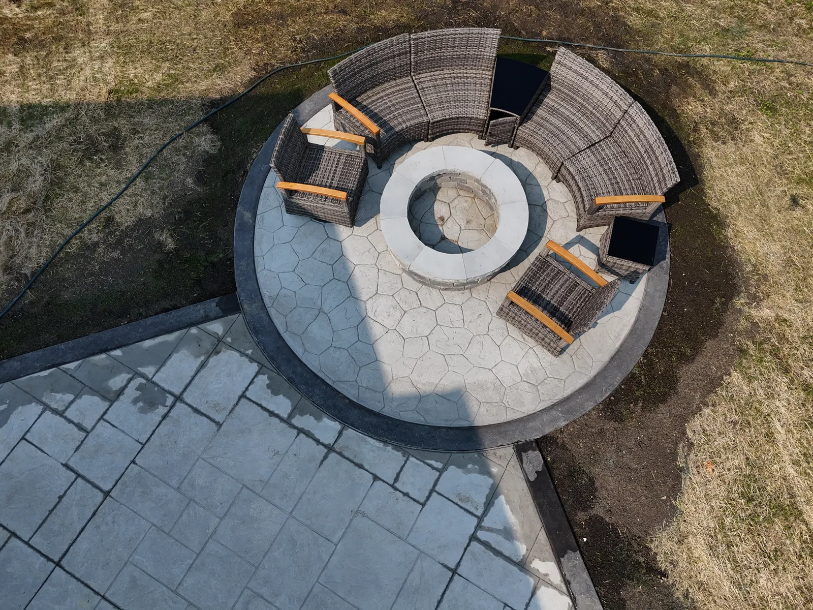 Circular cobblestone fire pit pad close-up with seating