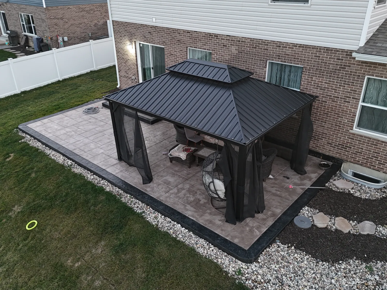 Stamped concrete patio with gazebo from angled drone perspective