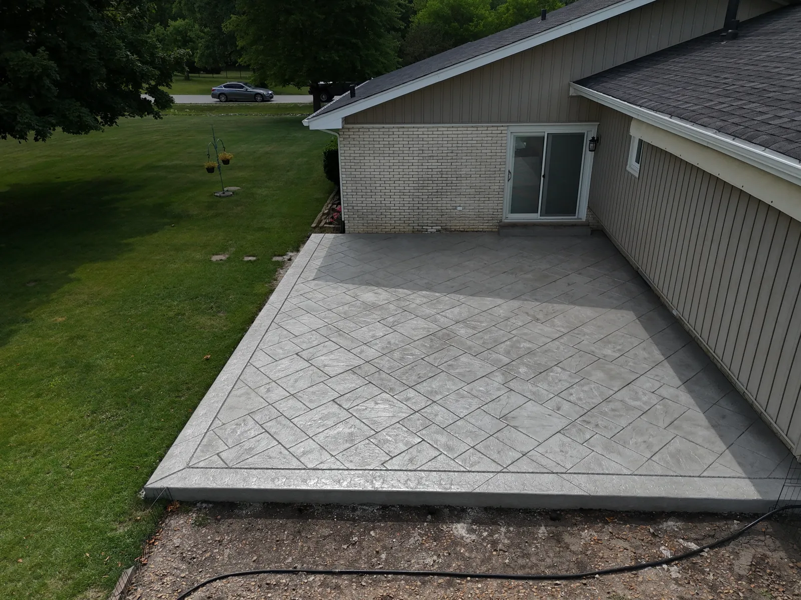 Gray ashlar stamped patio at ranch home with dark border