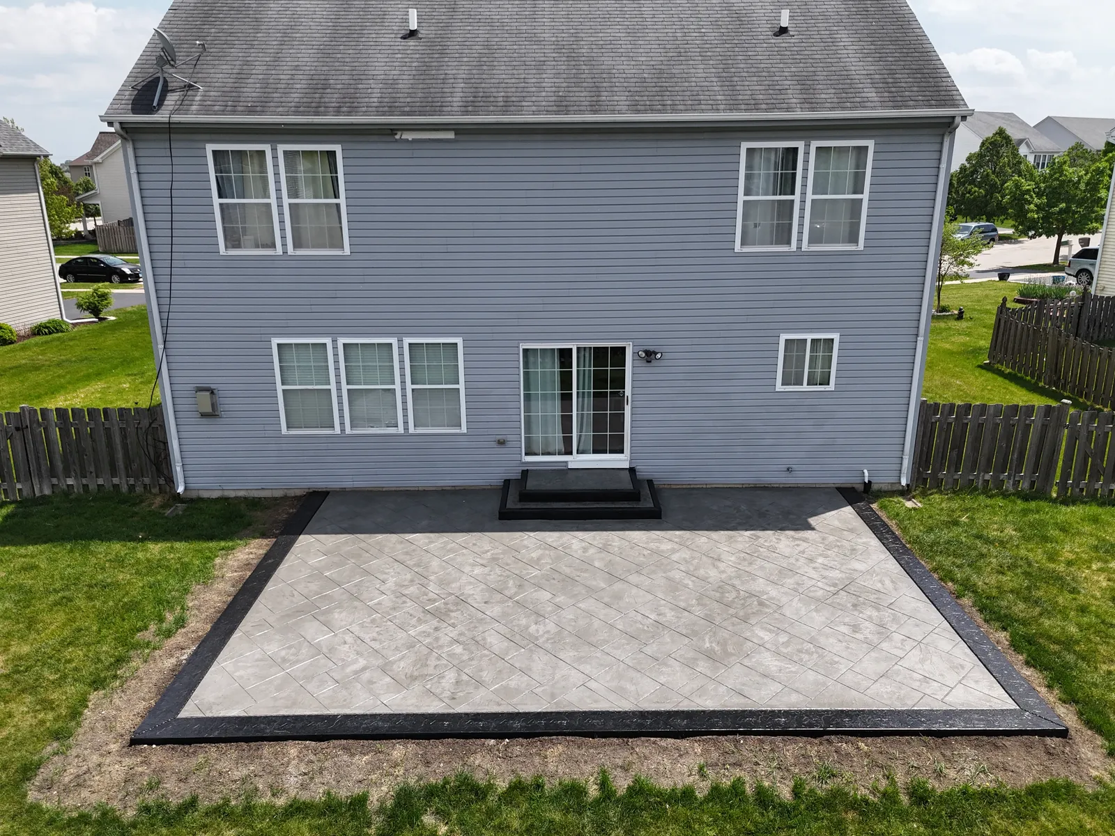 Gray stamped concrete patio with dark border — overhead drone view