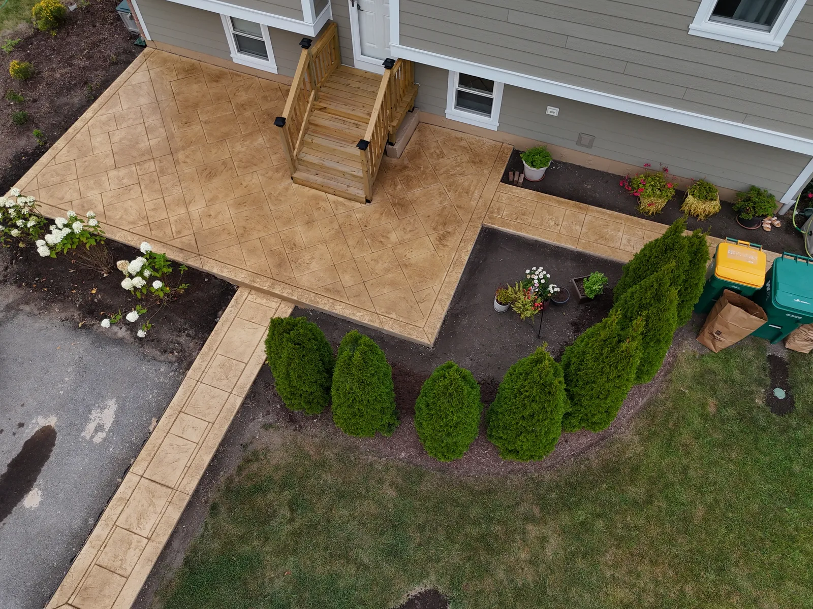 Stamped patio and walkway in golden hour light with cedar trees