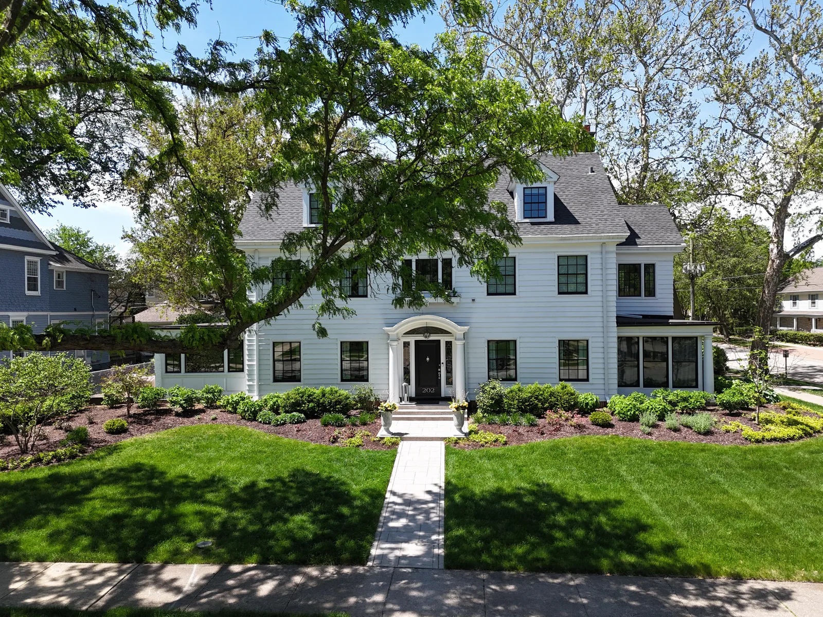 Stamped concrete walkway at white Colonial home — hero shot